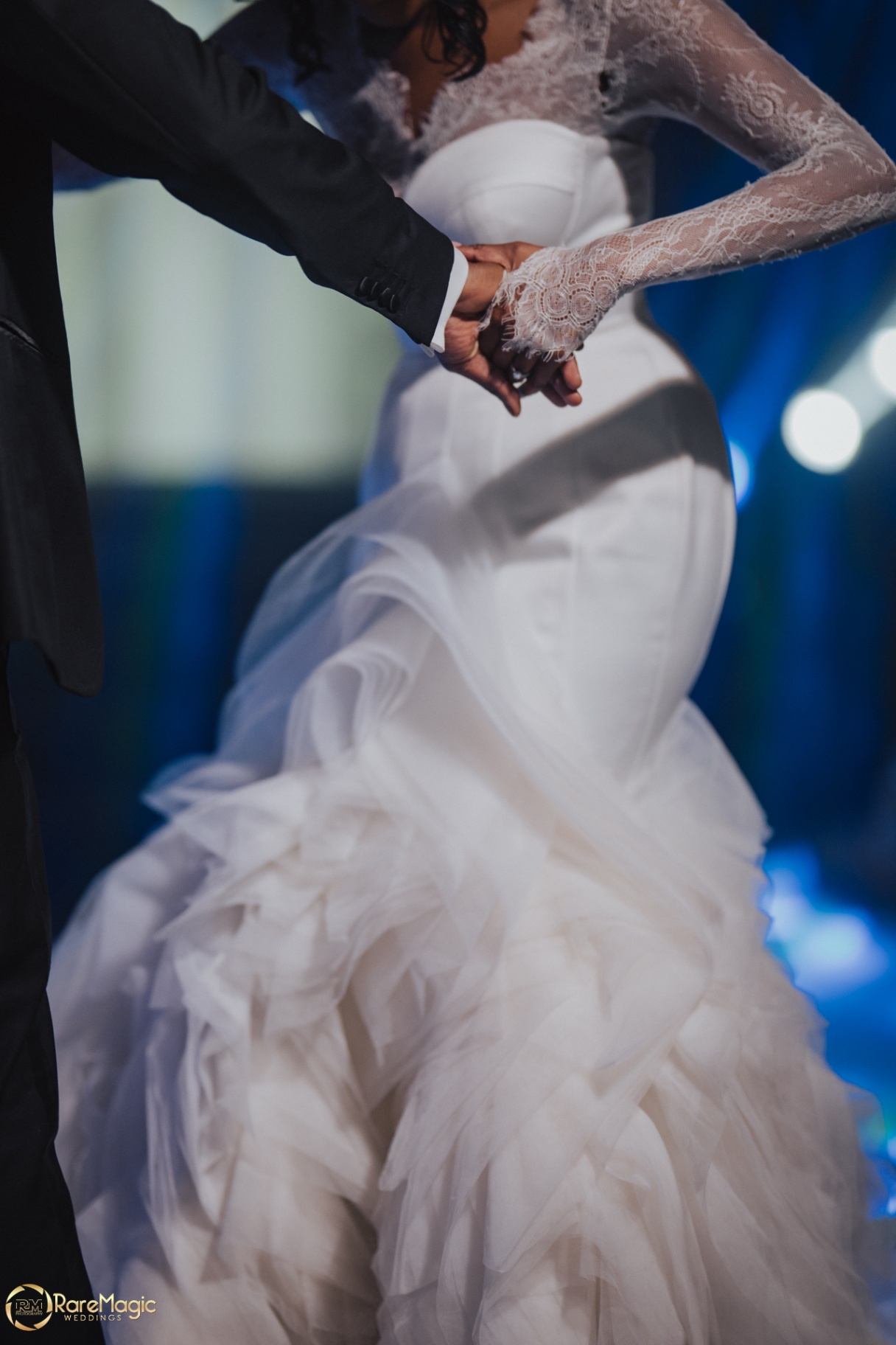 Close-up of the couple holding hands on the dance floor