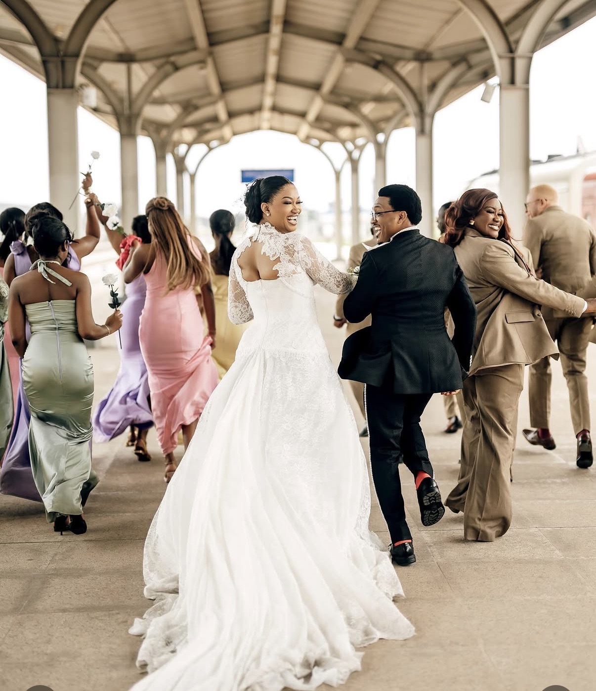 Bride and groom walking with bridal party at station