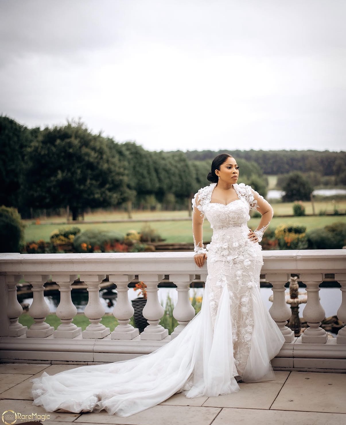 Bride in lace gown on balcony overlooking gardens