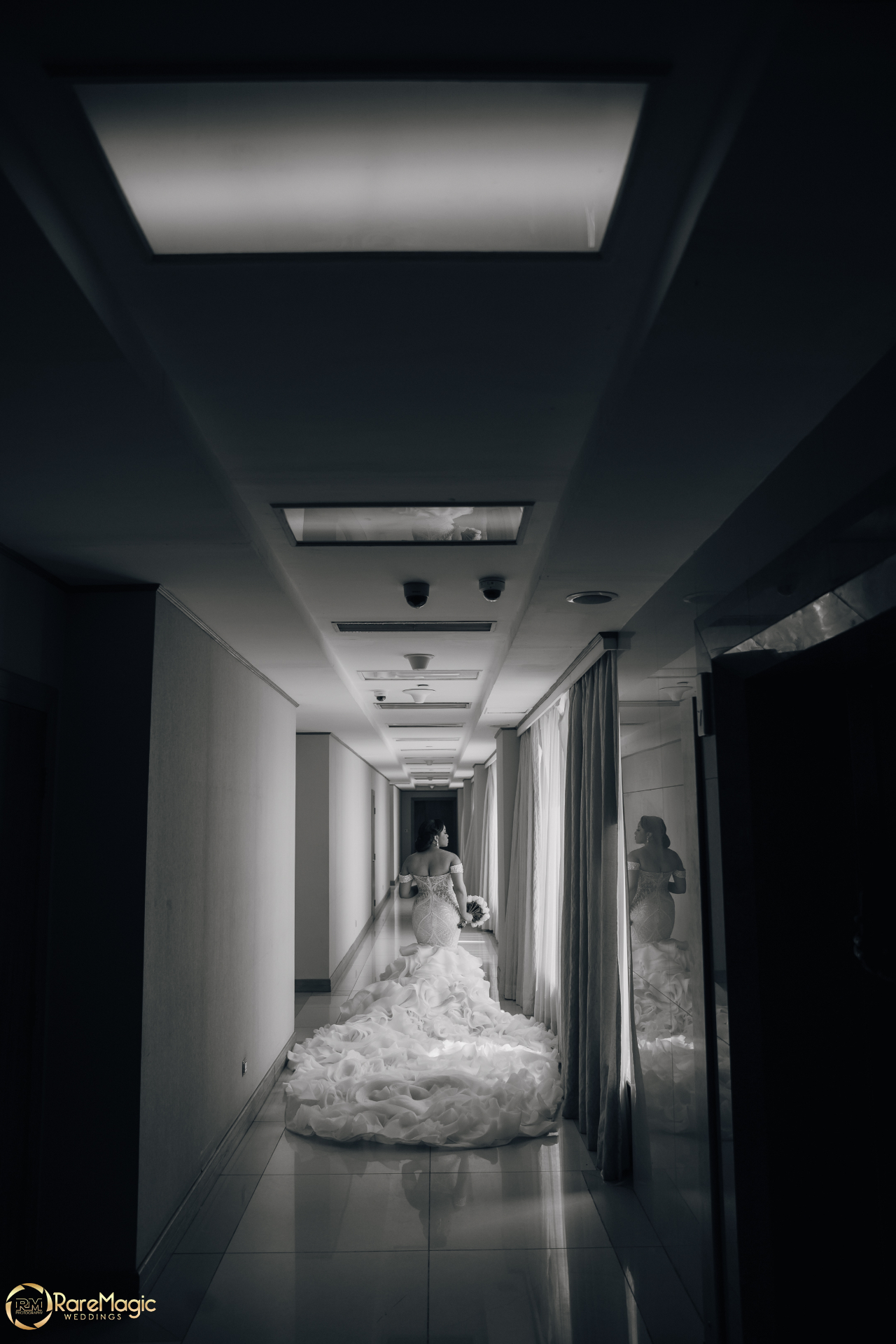 Black and white portrait of the bride in a ruffled mermaid gown in the corridor