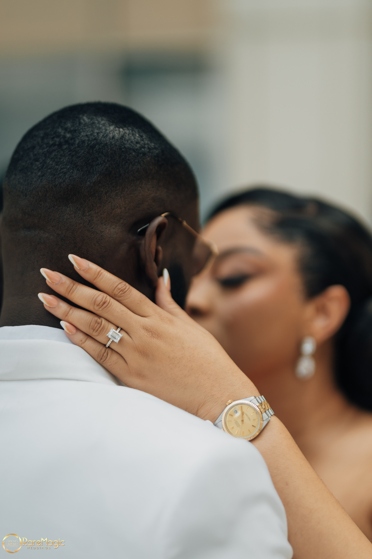 Intimate close-up of the bride embracing the groom with her diamond ring in focus