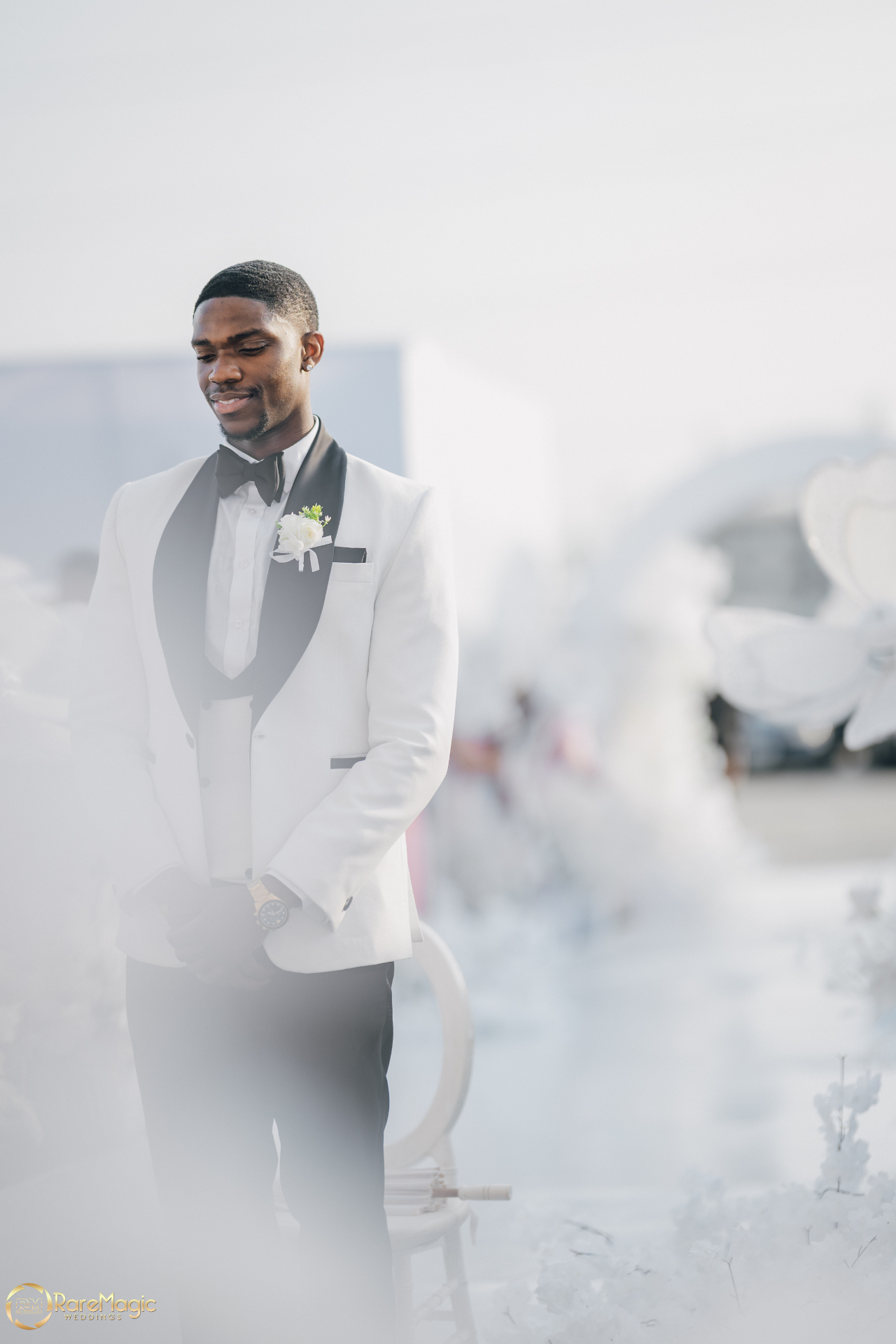 Groom in a white tuxedo with black lapels at the ceremony entrance