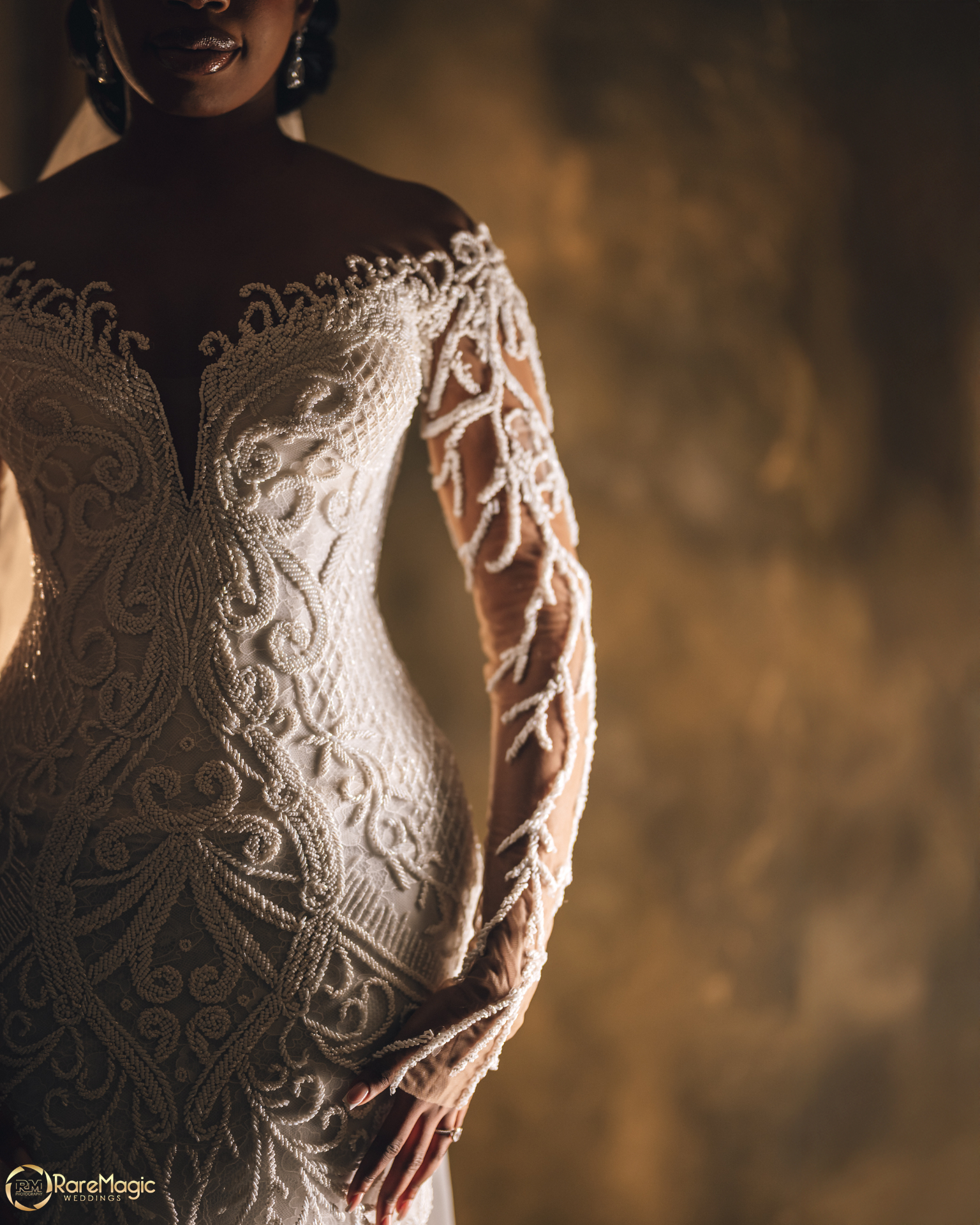Bride in intricately beaded lace gown in warm light