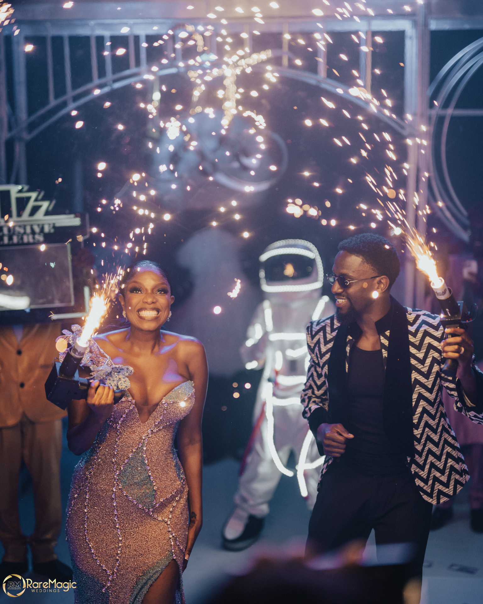 Couple with sparklers and an astronaut performer at the reception