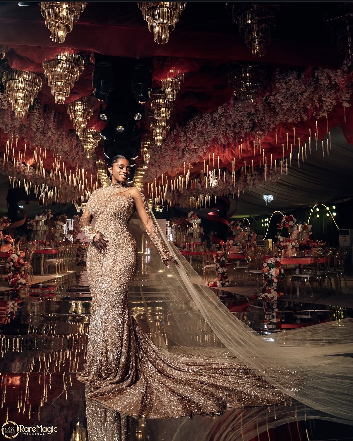 Bride in golden gown beneath grand chandeliers