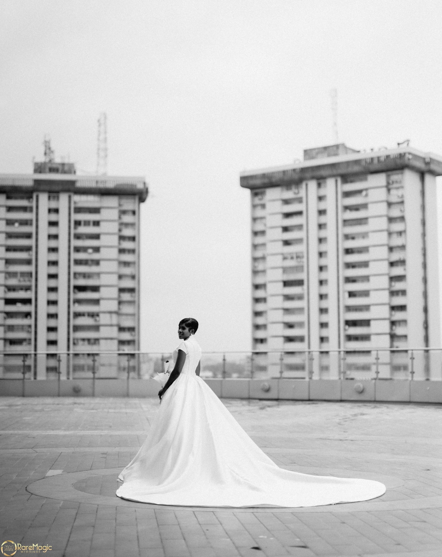 Bride on the rooftop with sweeping train and city skyline