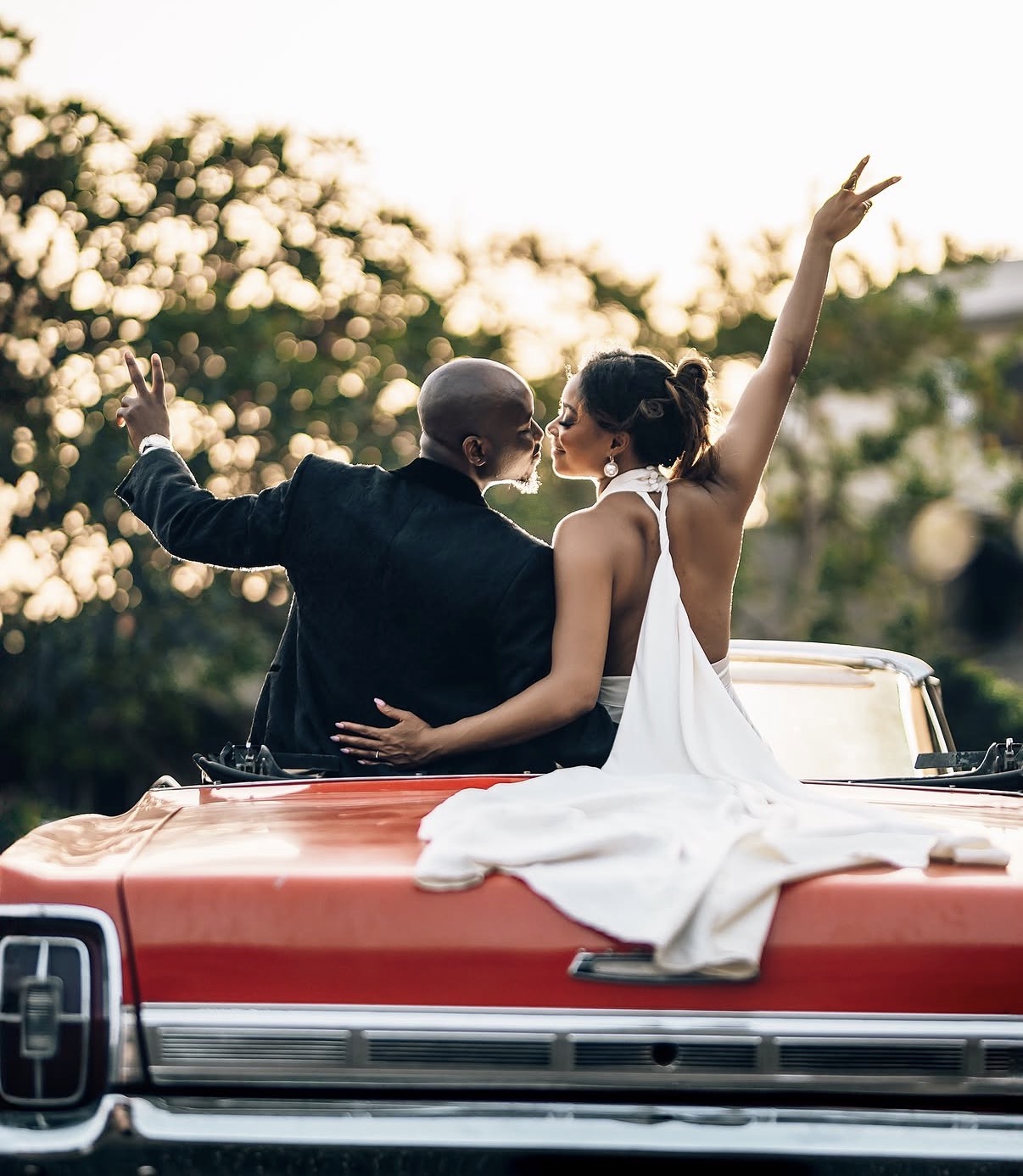 Couple in classic red convertible at sunset