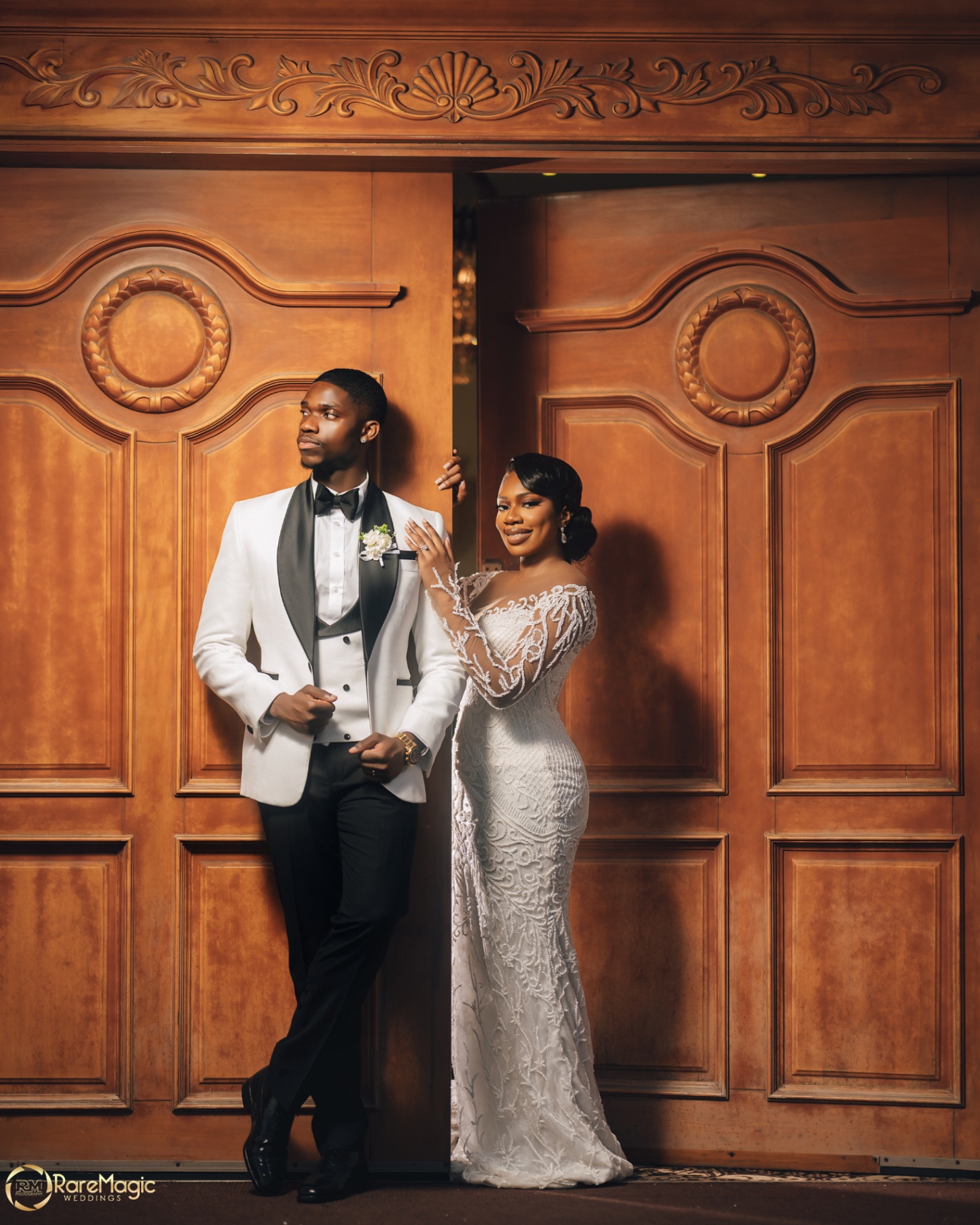 Portrait of the couple posed against carved wooden doors
