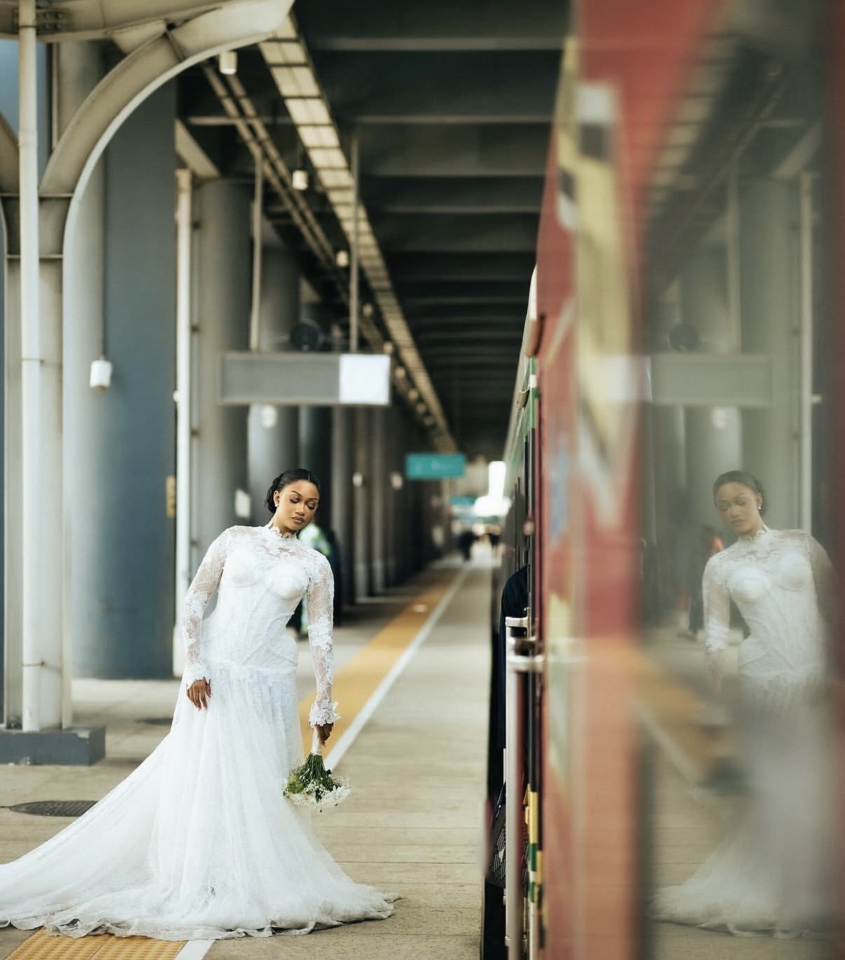 Bride at the train station with lace gown and bouquet