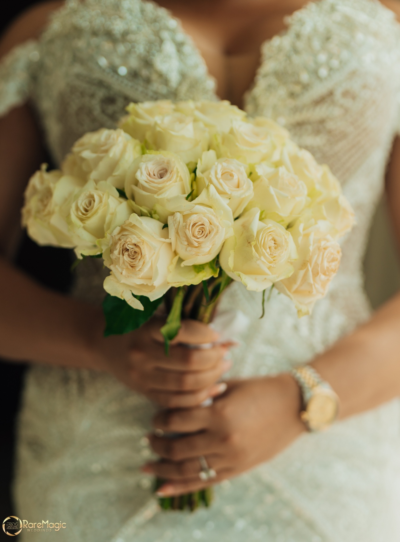 Close-up of the bride holding a cream rose bouquet