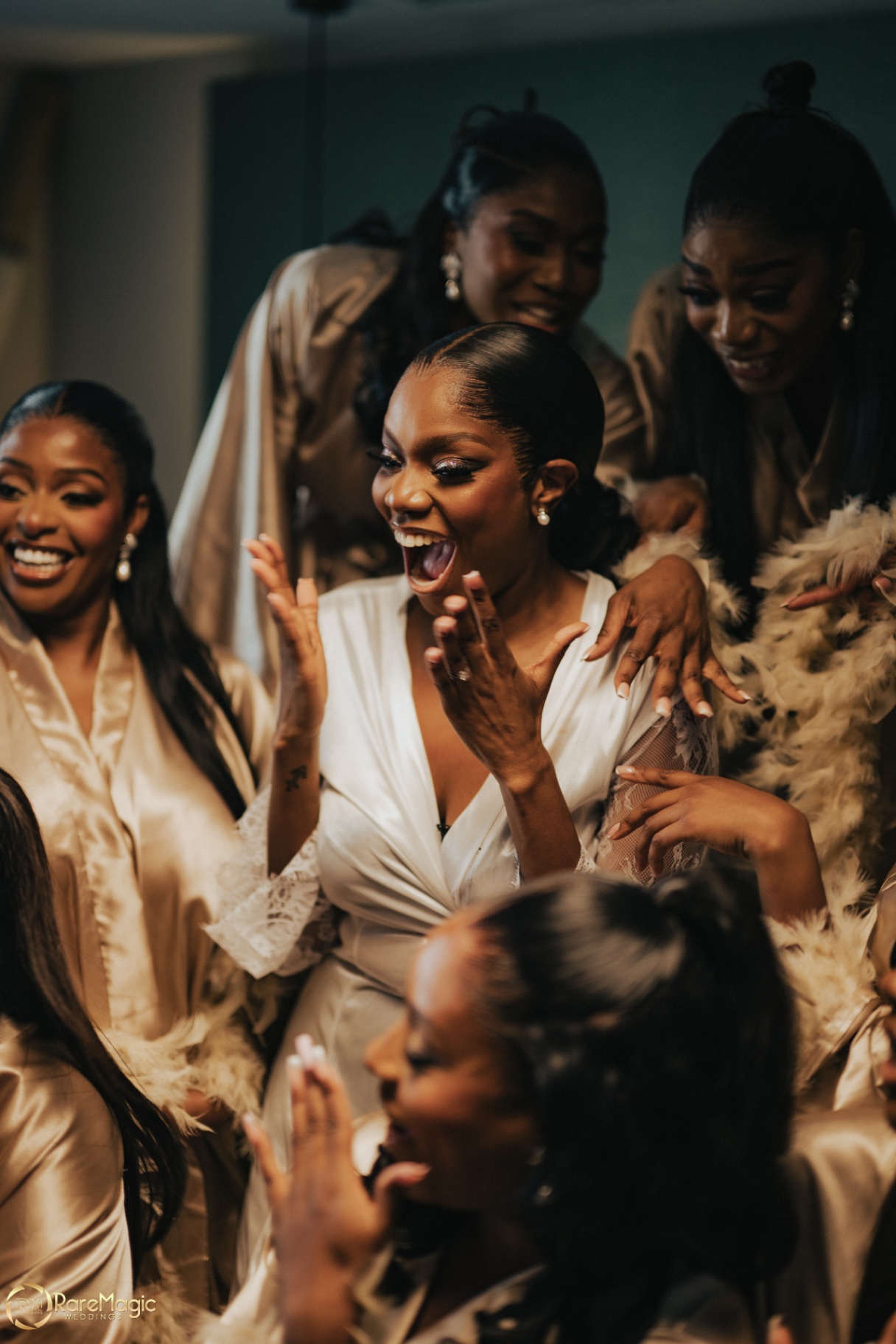 Bride laughing with her bridesmaids in robes