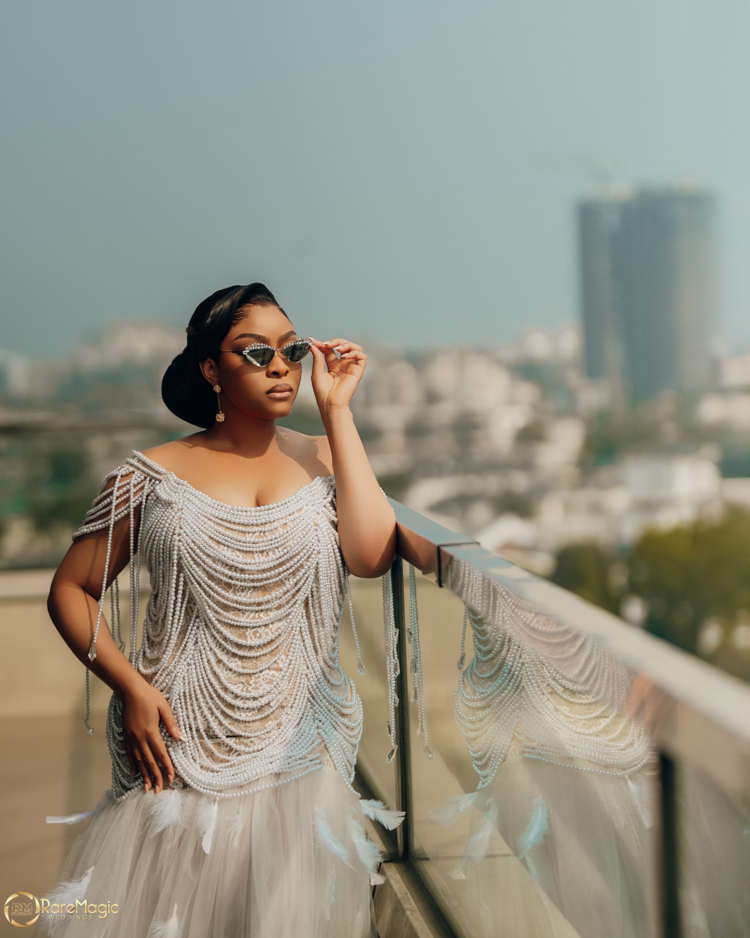 Bride on a city rooftop in pearl couture with cat-eye sunglasses