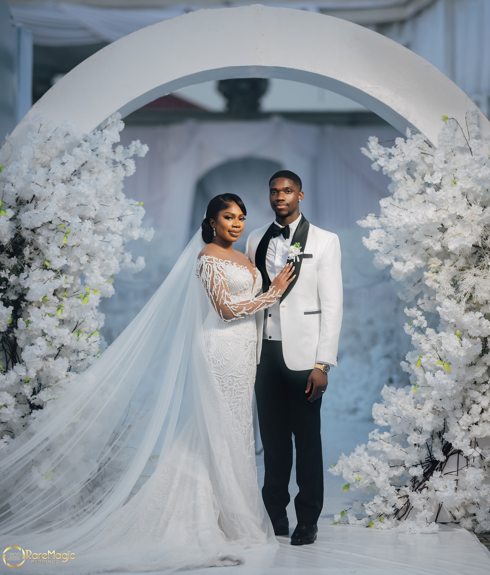 Couple beneath a floral arch in white florals
